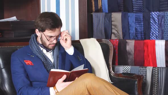 Handsome Businessman in a Classy Suit Having an Inspiration Mood Making Some Notes, While Sitting on