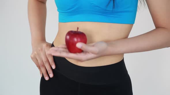 close up belly of woman and holding red apple