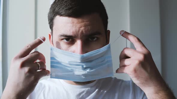 Guy with Small Beard Puts Medical Mask on and Breathes