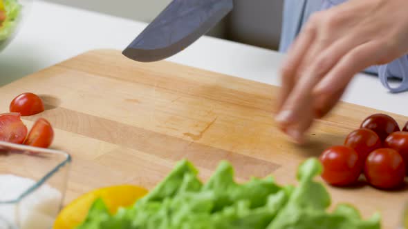 Woman Chopping Tomato with Kitchen Knife at Home