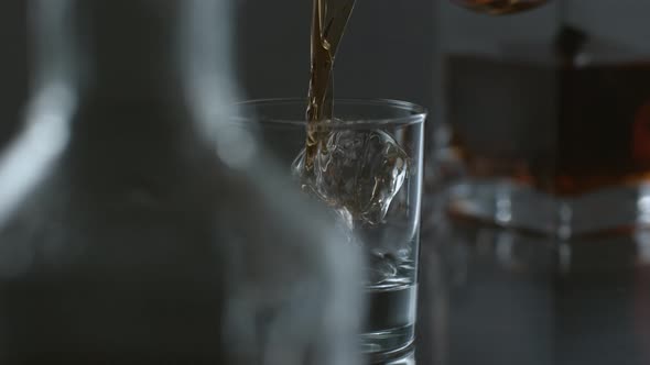 Whisky is poured over ice in slow motion; shot on Phantom Flex 4K at 1000 fps alt