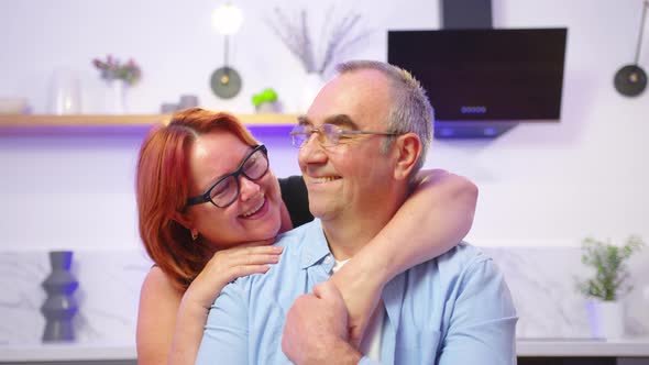 Cheerful Old Elderly Adult Family Couple Hugging Laughing Bonding Looking at Camera Smiling Healthy