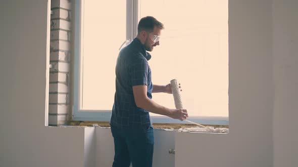 Smiling Man Applies Spray Foam and Joyful Girl Walks in Room