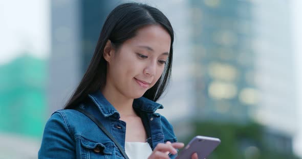 Woman hold with mobile phone in city