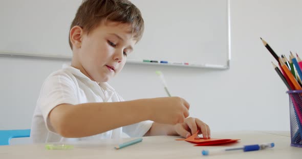 Little Cute Boy Draws with Pencils Is Engaged in Creativity at Home or in Kindergarten, Preparation