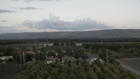 Backwards Aerial fly shot over Israeli green beautiful Kibbutz