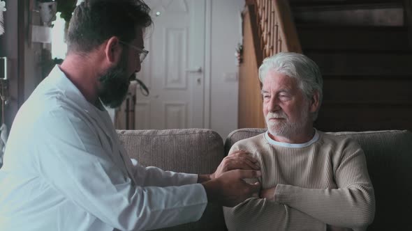 Male professional doctor consulting senior patient during medical care visit. Young man