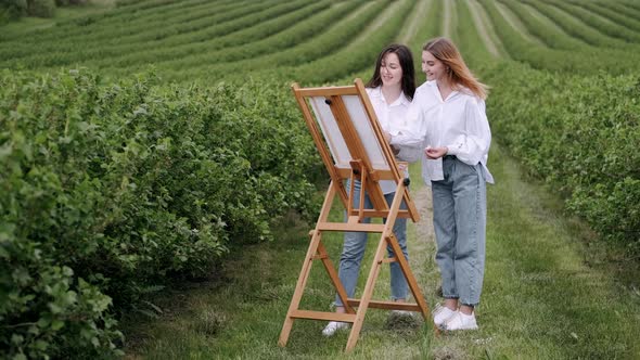 Elegant and Beautiful Girls Painting in a Field