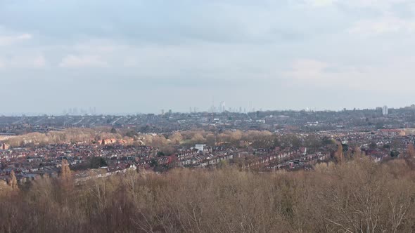 Dolly forward drone shot towards Central London skyline from Alexandra Palace gardens winter