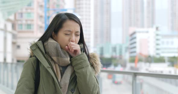 Woman sneezing at outdoor