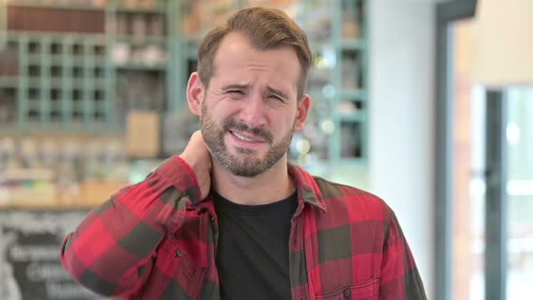 Portrait of Exhausted Young Man with Neck Pain