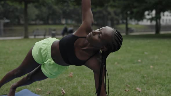 Sporty Woman with Afro Braids Practicing Yoga at Park