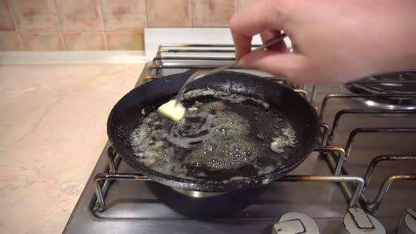 Cooking Eggs in a Skillet Pan with Butter Cast Iron Skillet on a Home Stove
