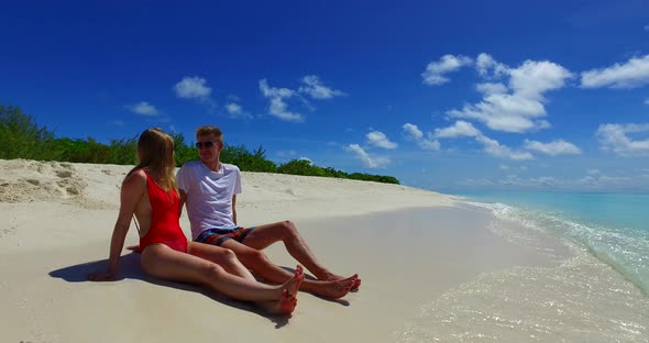 Beautiful people on honeymoon vacation live the dream on beach on paradise white sand 4K background