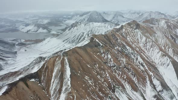 Drone Flight Arcing Over Mountain Landscape With Snow