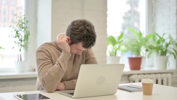 Tired Man Taking Nap While Sitting in Office with Laptop