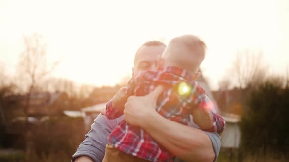 Young Father Playing with Little Son Outdoors