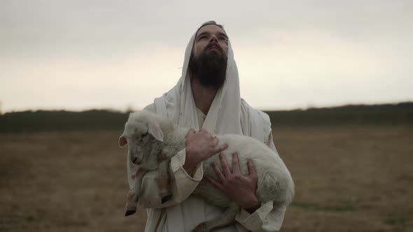 Jesus Christ The Good Shepherd Holds Lamb And Looks To God In Heaven