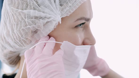 Cropped View of Doctor Putting on Mask Before Procedure