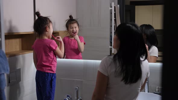 Evening Toothbrushing of Asian Mom and Daughter