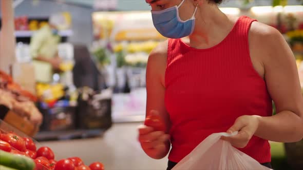 Young Woman in a Mask From a Coronavirus Epidemic Is Standing in the Grocery Department of a