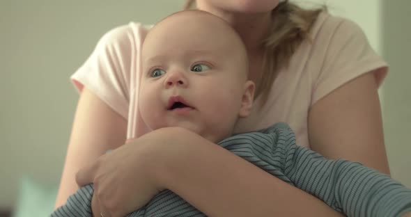 Cutie Baby Looking Around on Mother's Hands and Smiling