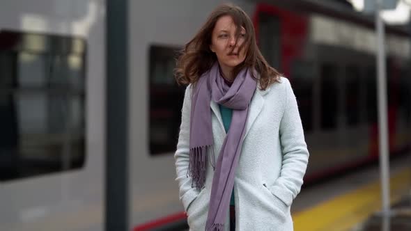 Thoughtful Woman Is Walking Over Open Platform of Train Station at Autumn Day