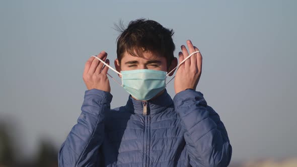 The End of the Coronavirus Pandemic. Happy Man Removes a Medical Mask From His Face, Close-up