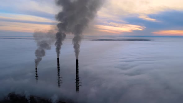 Aerial View of Coal Power Plant High Pipes with Black Smoke Moving Up Polluting Atmosphere at Sunset