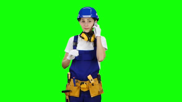 Builder Girl Is Standing and Talking on the Phone. Green Screen