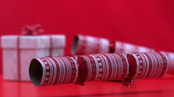 Christmas cracker spinning and bouncing beside present and bauble