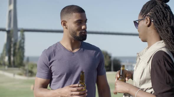 Happy African American Couple Talking While Drinking Beer.