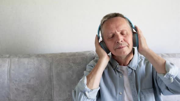 Cheerful Senior Retirement Gray Haired Man Listening Music on Headphones
