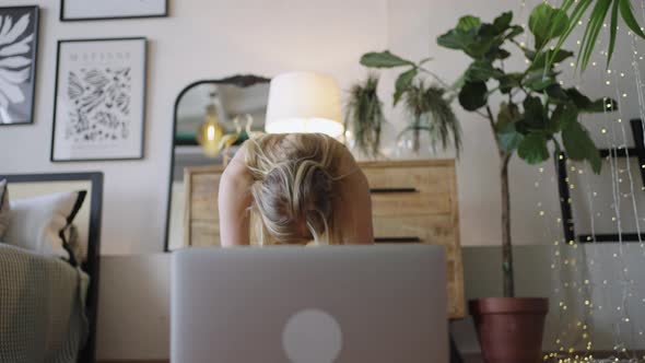 Blonde Woman Does Stretching Watching Tutorial Via Laptop