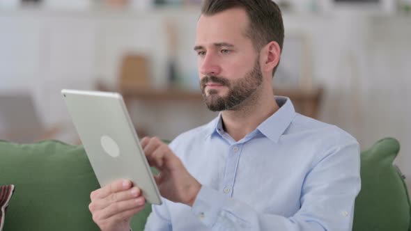 Young Man Using Tablet, Browsing Internet