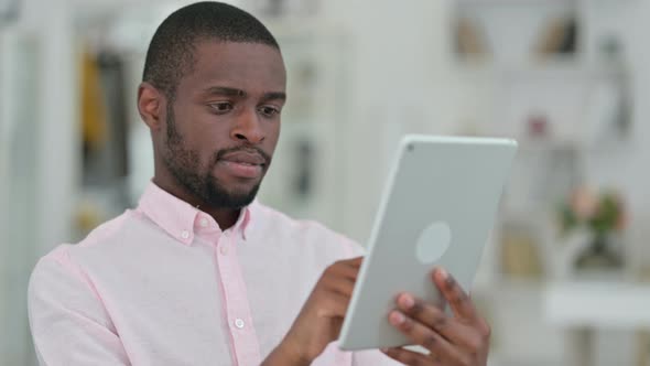 Portrait of Focused African Man Using Digital Tablet 