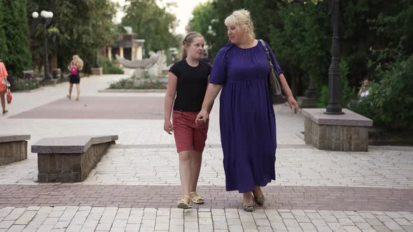 Fat Woman and Girl Walking at the City