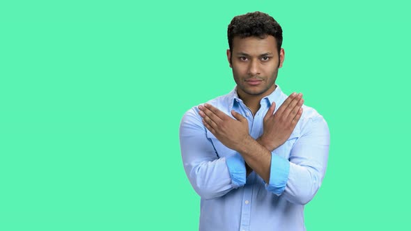 Confident Young Man Showing Gesture with Crossed Hands