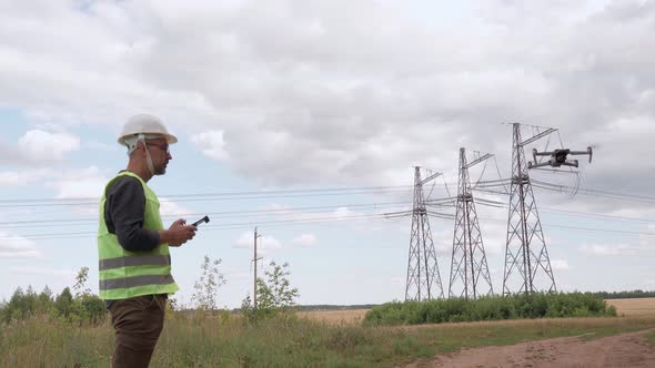 An Electrical Engineer Inspects Highvoltage Power Lines Using a Drone