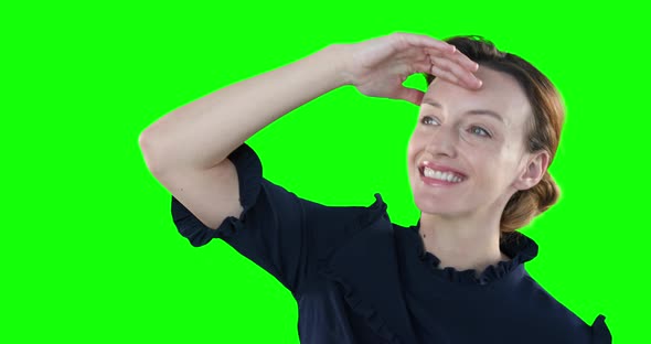 Caucasian woman raising hand on green background