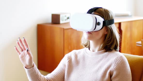 Woman using virtual reality headset in living room