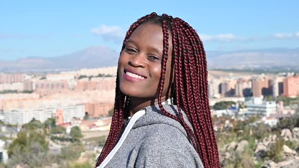 African Woman with Dreadlocks is Dancing and Smiling