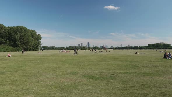 An east London park on a sunny day. We can see the Olympia Park in the far distance.