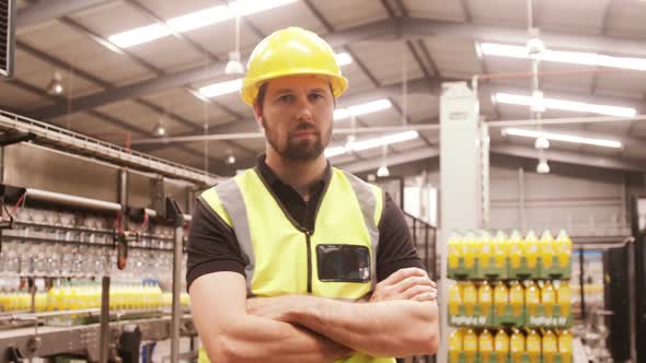 Worker standing with arms crossed in factory