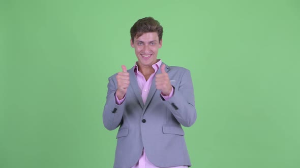 Happy Young Businessman Giving Thumbs Up and Looking Excited