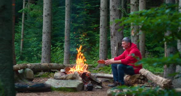 Bearded Male Tourist Near Campfire in the Forest