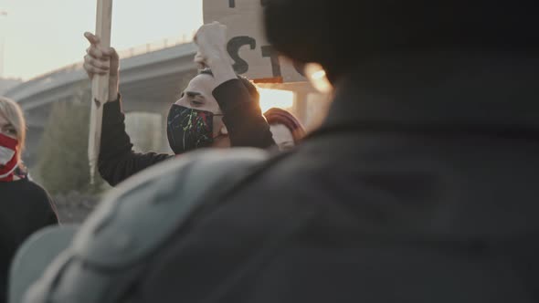 Active Young People Protesting before Riot Police with Shields