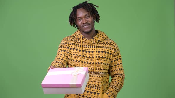 Young Happy Handsome African Man Giving Gift Box