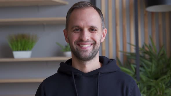 Portrait of a Handsome Young Man Smiling While Standing in the Office