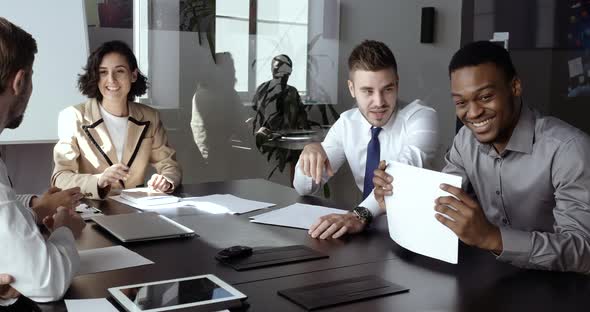 Group of Smart Multiracial Young Managers Office Workers Sitting at Table in Conference Room